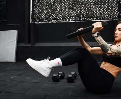 A determined woman performs a core workout in an indoor gym setting.