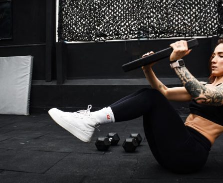 A determined woman performs a core workout in an indoor gym setting.